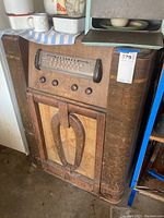 Side view showing wooden radio cabinet with curved corners and fabric speaker grille.