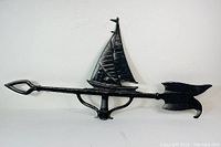 Side view of black aluminum sailboat weathervane showing detailed sail and arrow-shaped pointer.