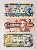 Front of $5, $2, and $1 Canadian banknotes showing portraits and monetary values