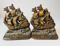 Pair of cast iron nautical clipper ship bookends shown side by side, highlighting the ship details, sails, and wave base.