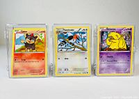 Front view of three Pokémon cards Litleo, Fletchinder, and Drowzee, each in protective cases.