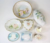 Top-down view of all eight pieces arranged showing various shapes and floral decorations, highlighting the variety and condition