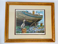 Full view of the framed vintage print showing the pelican, boat, and surroundings, with wooden frame and matting.