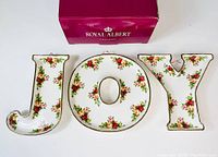 Front view of J, O, Y bone china dishes with floral pattern and original box behind them