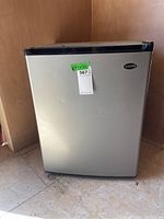 Closed view of the stainless steel Sanyo mini fridge showing front and top edges.