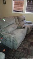 Gray fabric sectional sofa two-piece setup with removable center containing cup holders.
