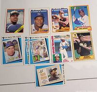 Photo showing a collection of 10 vintage Topps baseball cards laid out on a white surface. Cards feature various famous players and styles including 'Future Star' and 'Turn Back the Clock' series.
