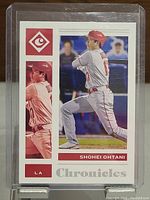 Front view of 2021 Shohei Ohtani LA Chronicles baseball card in protective case, showing action photos of Ohtani and branding.