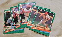 Photo showing five 1990 Donruss World Series baseball cards featuring players Billy Hatcher, Jose Rijo, Willie Randolph, among others laid out on a flat surface.