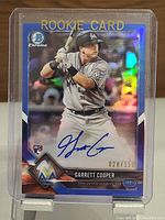 Front of Garrett Cooper Bowman Chrome Rookie Card showing holographic rookies design, autograph, and serial number 028/150.