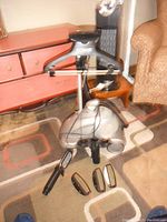 Full view of the silver Conair garment steamer with expandable pole, black hanger, and multiple attachments displayed on the floor.
