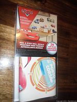 Photo of Disney Cars wall decal package featuring Lightning McQueen and other characters, showing 26 pieces included.