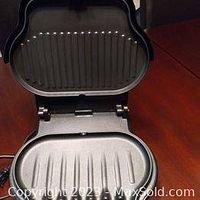 Mini George Foreman grill opened showing ribbed grilling surface