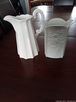 White porcelain vase and white pitcher placed side by side on a wooden table