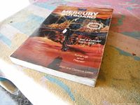 Photo of the manual's front cover showing the title, graphic of a Mercury outboard motor, and authors Joan and Clarence Coles.