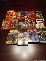 Top down view of 14 comic books showing Spider-Man, Batman, X-Men and Hulk series covers with colorful artwork