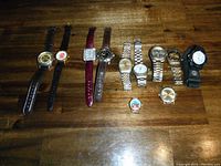 Overview of all 11 watches with various band styles including leather, metal, and fabric. Two watches without bands visible, one with a cartoon face.