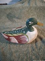 Side view of vintage hand-painted wooden duck decoy on fabric background