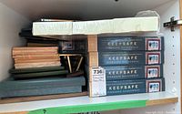 Multiple wooden frames and boxed Keepsafe pinboard shadowboxes stacked together