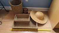 Photo showing all wicker items and the straw hat together with a measuring tape for scale on the floor.