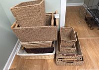 Stack of various wicker baskets and trays, multiple sizes and shapes shown.