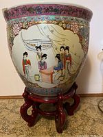Front view of ceramic planter showing hand-painted Asian women in traditional dress and floral pattern with gold accents on pink background.