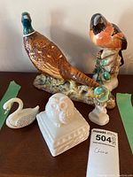 Full arrangement of all bird figurines and owl head box on wood surface