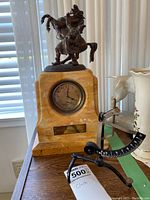 Full view showing yellow marble clock base with bronze horse and man sculpture on top