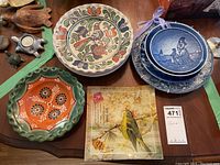 Full view of display bowls and square glass plate on wooden surface.