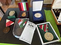 Overview of six medals including some in display boxes, showing ribbons and metal insignia