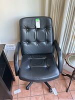 Front view of the black office chair showing cushioned backrest and armrests