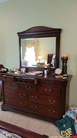 Full view of dresser and mirror set against wall, top surface with various items removed by seller