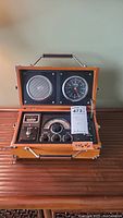Full open view of the radio alarm clock showing speaker, analog clock, and radio controls in wooden case.