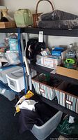 Overall view of one shelving unit fully loaded with various items including storage bins, household products, and miscellaneous items on the shelves.