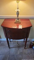 Demilune wooden table with two drawers, showing front and legs detail