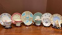 Group photo showing five bone china teacups and saucers with varied floral and geometric patterns in pastel and vivid colors.