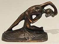 Side view of bronze female nude dancer sculpture showing flowing lines and copper finish with patina