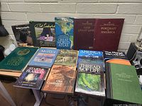 Overall view of 14 books on table showing various titles and themes including animals, atlas, art, nature, and science.