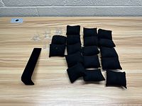 Photo showing the black velvet jewelry display pillows, black velvet elongated stand, and clear plastic ring holders spread on a table.