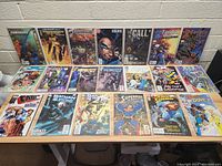 Lot of 20 comic books laid out on a table showing front covers. Various titles from Marvel, DC, and IDW Publishing.
