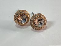 Front view of the pair of Swarovski large halo crystal pave setting stud earrings in rose gold tone showing the clear large central crystals and surrounding smaller pave crystals.
