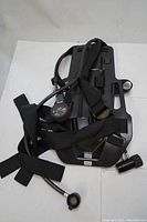 Full view of the North Frontier black molded backplate with attached straps, pressure gauge, and air hose assembly.