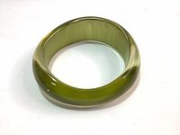 Top view of a green translucent resin bracelet showing its rounded thick band and glossy finish.