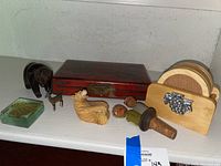Overview of wooden box with abacus, two bear figurines, glass paperweight, dog figurines and cork coaster set with caddy