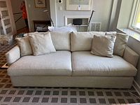 Front view of tan sofa with cushions and throw pillows