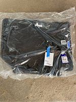 Photo of the sealed black textile carpet mats in clear plastic packaging with visible Volvo label.