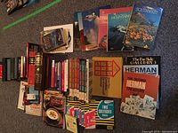 Overview photo showing a variety of books including cookbooks, travel guides, and magazines laid out on carpet.