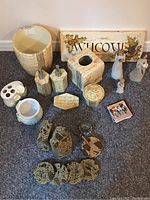 Photo shows assorted decorative bathroom items including the 'Welcome' sign with holly design, Willow Tree angels, stone-textured bookends, coasters, ceramic containers and a booklet.