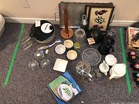Overall photo showing many kitchen items including tray, coffee grinder, French press, salad spinner, ramekins, candle holders, sifter, paper towel holder, and other items.