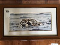Framed original painting of an animal swimming, artist signature visible.